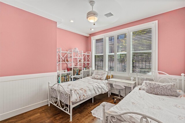 bedroom featuring visible vents, wainscoting, and wood finished floors