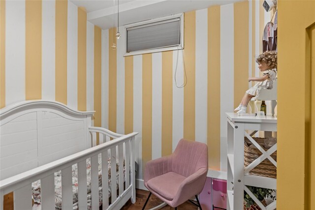 bedroom with a nursery area and wallpapered walls