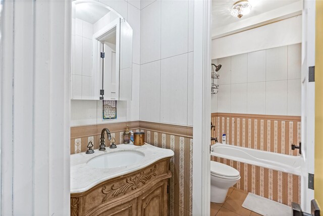 bathroom with toilet, tile patterned floors, wallpapered walls, and vanity