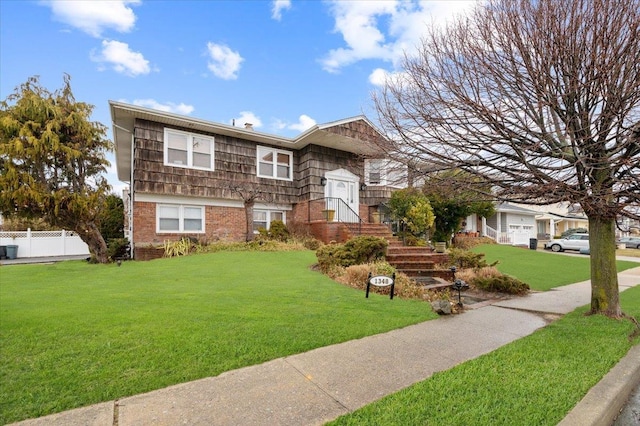 view of front of property with fence, a front lawn, and brick siding
