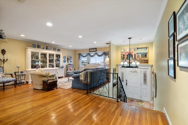 living room featuring crown molding, recessed lighting, light wood finished floors, and baseboards