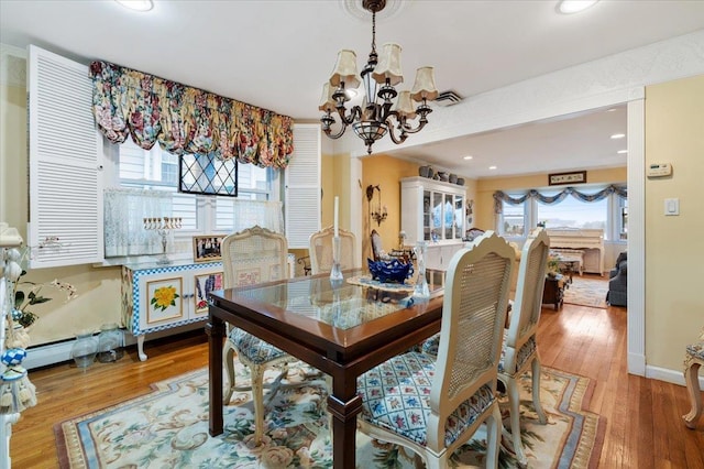 dining room with recessed lighting, wood finished floors, and a chandelier