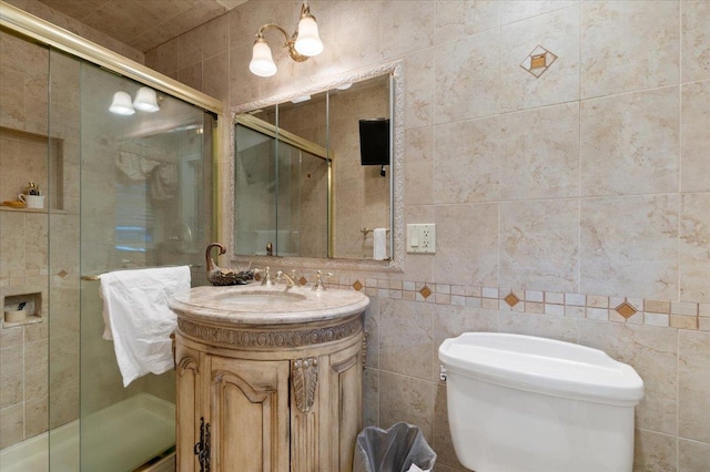 full bathroom featuring vanity, a shower stall, toilet, and tile walls