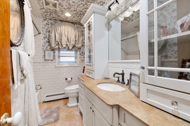 bathroom featuring vanity, toilet, tile walls, tile patterned floors, and a baseboard heating unit