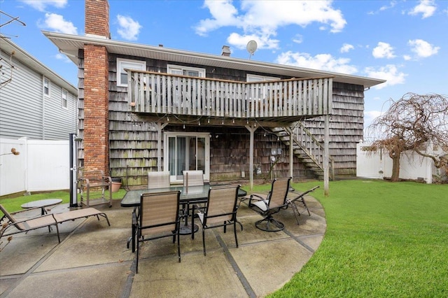 view of patio / terrace featuring outdoor dining space, a wooden deck, fence private yard, and stairway