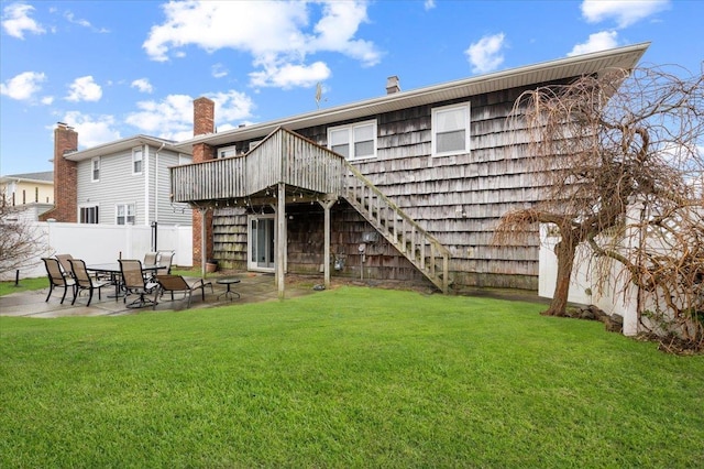 rear view of property with fence, a wooden deck, stairs, a patio area, and a yard