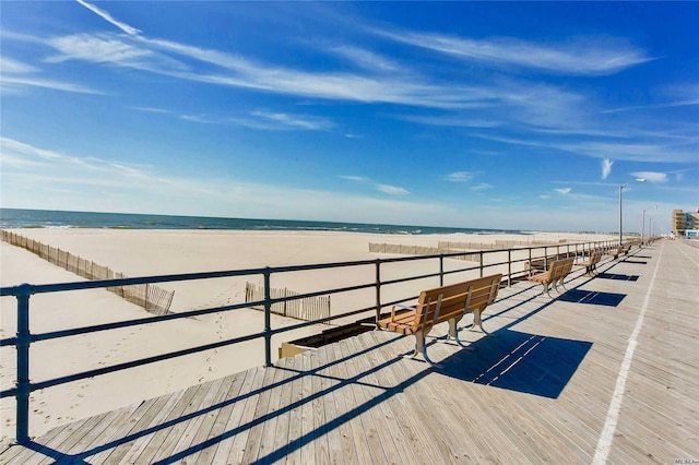 view of dock featuring a water view and a view of the beach
