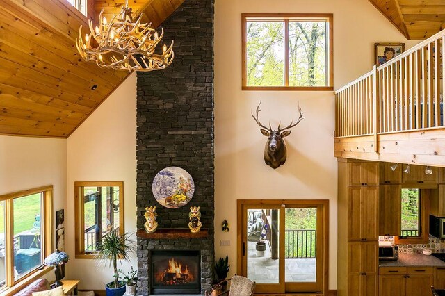 43 Bee Tree Ln, Accord, NY 12404 - living room featuring high vaulted ceiling, wooden ceiling, a stone fireplace, a chandelier, and healthy amount of natural light