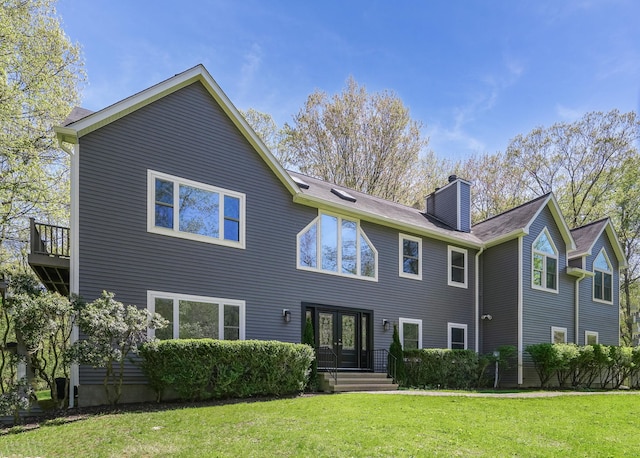 back of house with a lawn, french doors, and a chimney