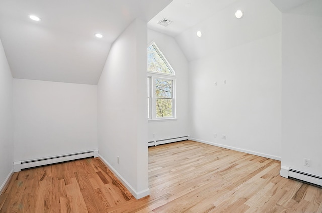 additional living space featuring baseboard heating, vaulted ceiling, and wood finished floors