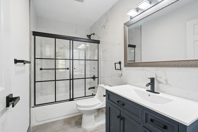 full bathroom with tile walls, tasteful backsplash, vanity, toilet, and enclosed tub / shower combo