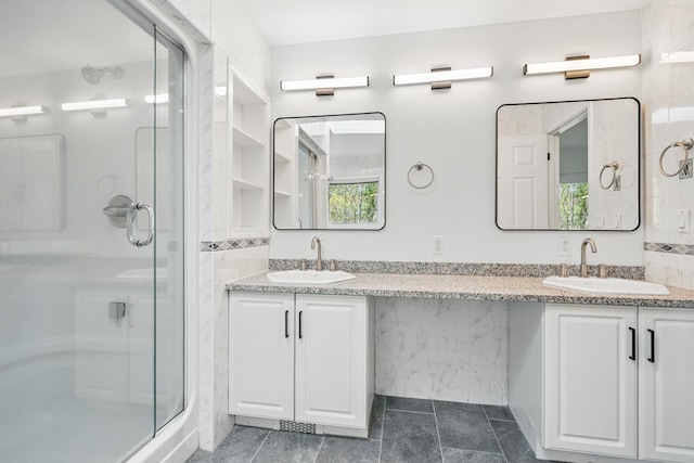 full bath featuring a sink, a shower stall, and double vanity