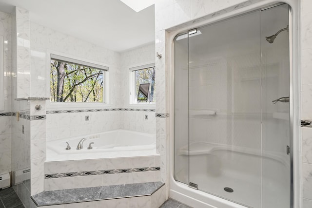 bathroom with tile walls, a garden tub, and a stall shower