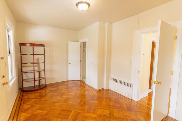 empty room with baseboards and radiator heating unit