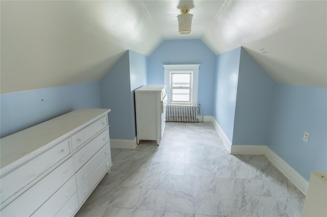 additional living space featuring baseboards, lofted ceiling, and radiator
