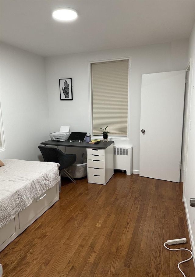 bedroom featuring radiator and wood finished floors
