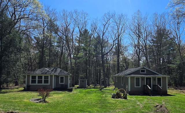 view of yard featuring a wooded view and an outbuilding