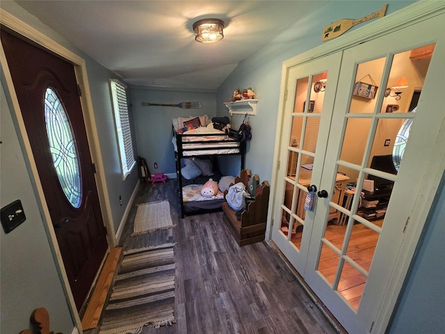 bedroom featuring vaulted ceiling, baseboards, french doors, and wood finished floors