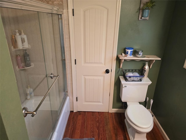 full bathroom featuring toilet, baseboards, shower / bath combination with glass door, and wood finished floors