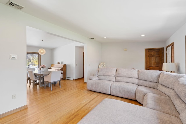 living room featuring recessed lighting, visible vents, light wood-style flooring, and a baseboard heating unit
