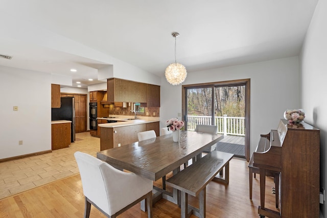 dining space with visible vents, light wood-type flooring, baseboards, lofted ceiling, and recessed lighting