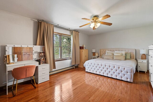 bedroom featuring baseboard heating, a ceiling fan, and light wood finished floors