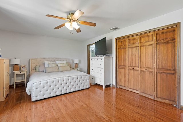 bedroom featuring visible vents, ceiling fan, wood finished floors, and a closet