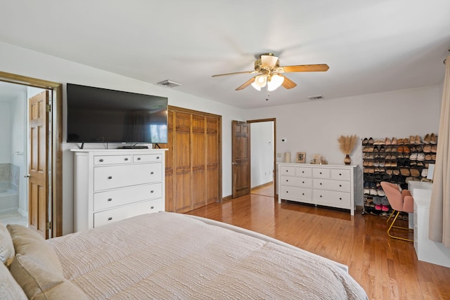 bedroom featuring ceiling fan, visible vents, and wood finished floors