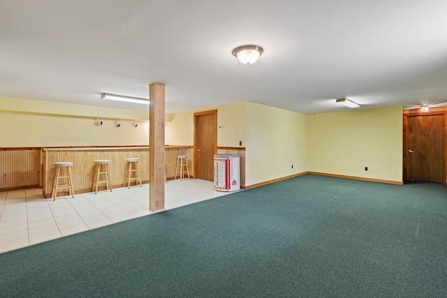 finished below grade area with a dry bar and carpet flooring
