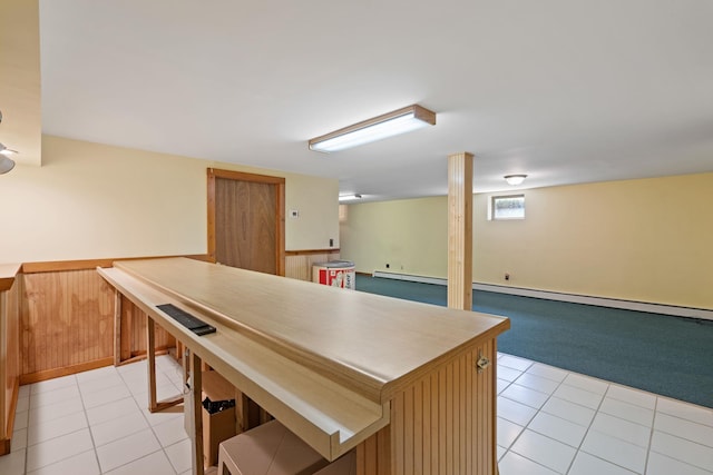 kitchen featuring light colored carpet, open floor plan, a baseboard heating unit, and light tile patterned floors
