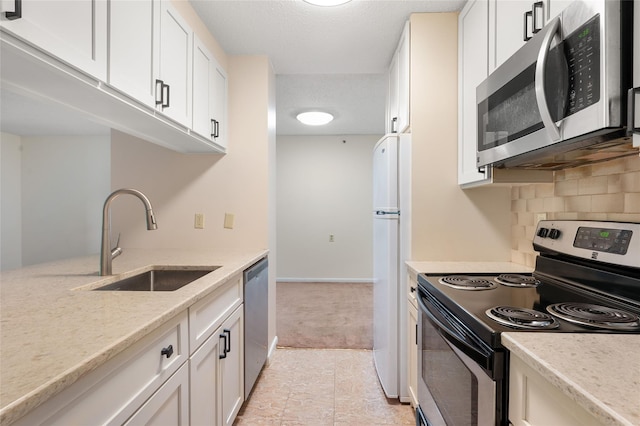 25 Rockledge Ave Unit 601, White Plains, NY 10601 - kitchen featuring appliances with stainless steel finishes, a sink, white cabinetry, decorative backsplash, and light colored carpet