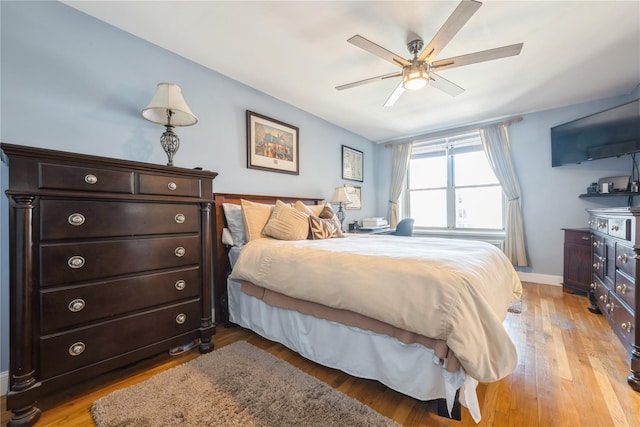 bedroom with baseboards, light wood finished floors, and ceiling fan