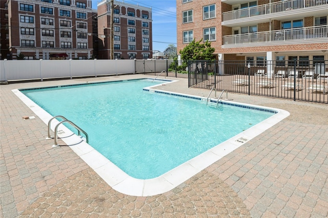 community pool featuring fence and a patio