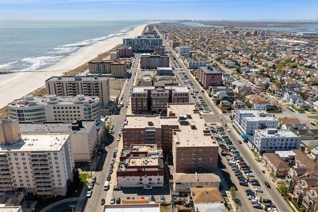 drone / aerial view featuring a beach view, a water view, and a view of city