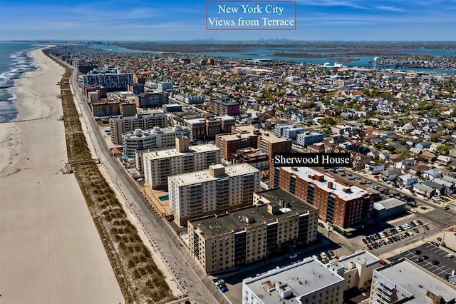 birds eye view of property featuring a beach view, a water view, and a view of city