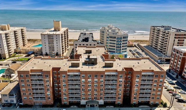 aerial view of waterfront with a beach and apartment complex