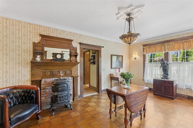 dining room with crown molding, wallpapered walls, and a wood stove