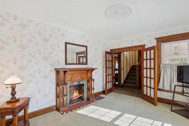 living area featuring stairway, baseboards, french doors, and a fireplace with flush hearth