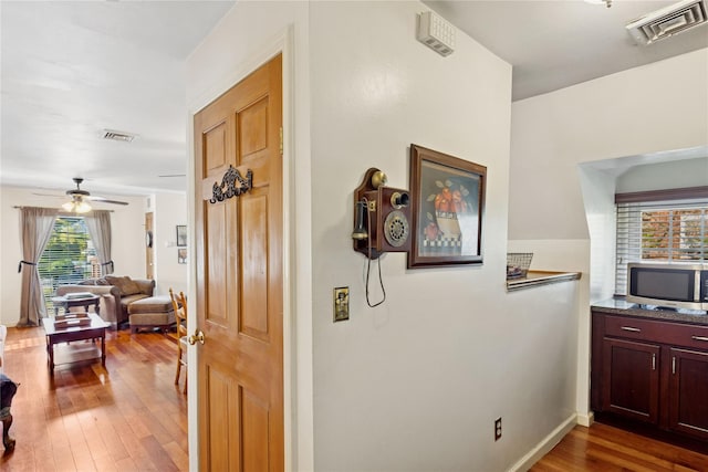 hallway with visible vents and hardwood / wood-style floors