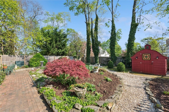 view of yard with a storage shed, an outbuilding, and a fenced backyard