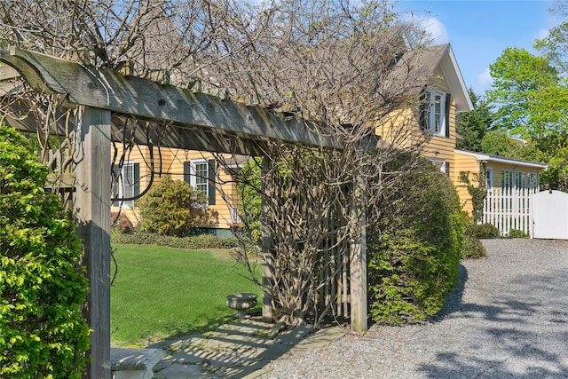 view of home's exterior featuring roof with shingles, fence, and a yard