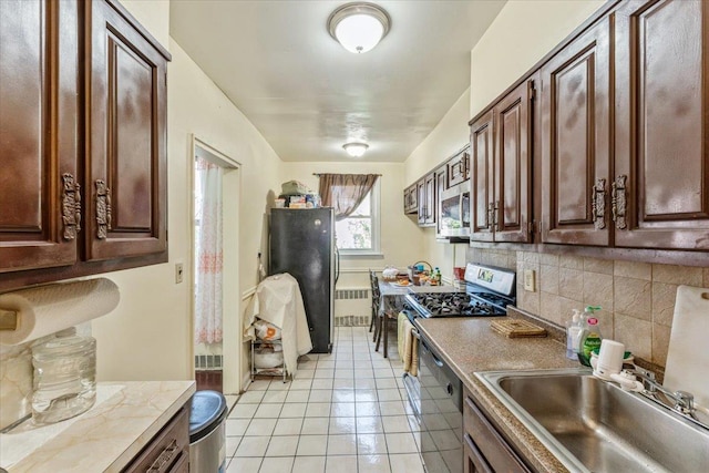 kitchen featuring a sink, light countertops, stainless steel appliances, light tile patterned floors, and backsplash