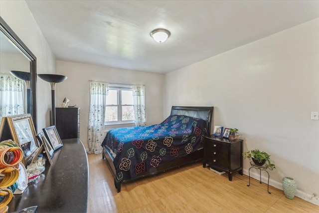 bedroom featuring baseboards and wood finished floors
