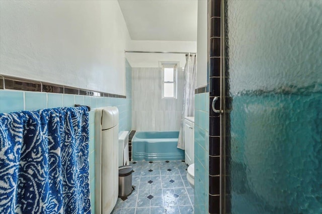 bathroom featuring a bath, tile walls, tile patterned flooring, a shower stall, and toilet