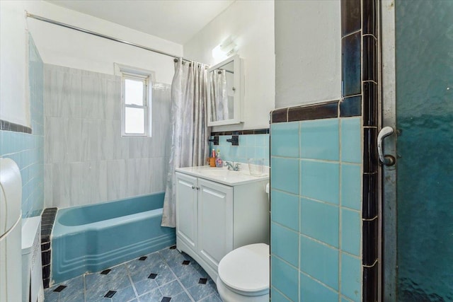 bathroom featuring tile walls, tile patterned flooring, vanity, toilet, and shower / bath combo with shower curtain