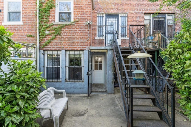 property entrance with brick siding and a patio area