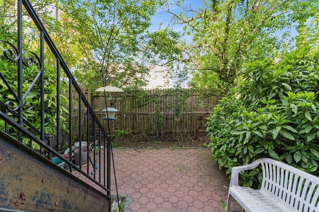 view of patio with fence and stairs