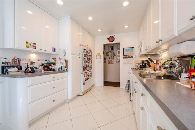 kitchen with white appliances, white cabinetry, recessed lighting, and a sink