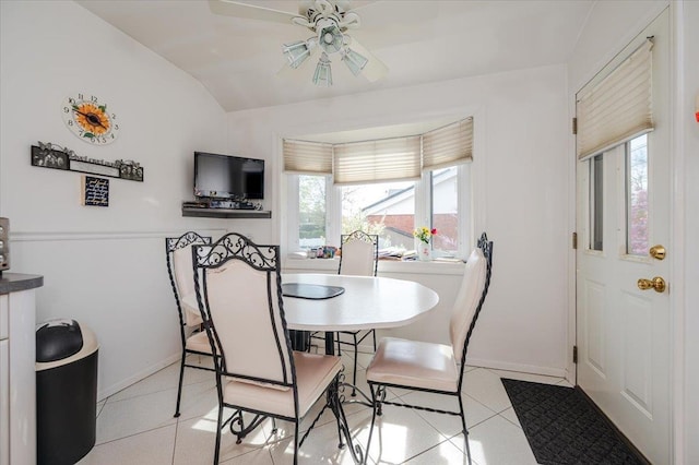 dining area with a ceiling fan, baseboards, light tile patterned floors, and a wealth of natural light