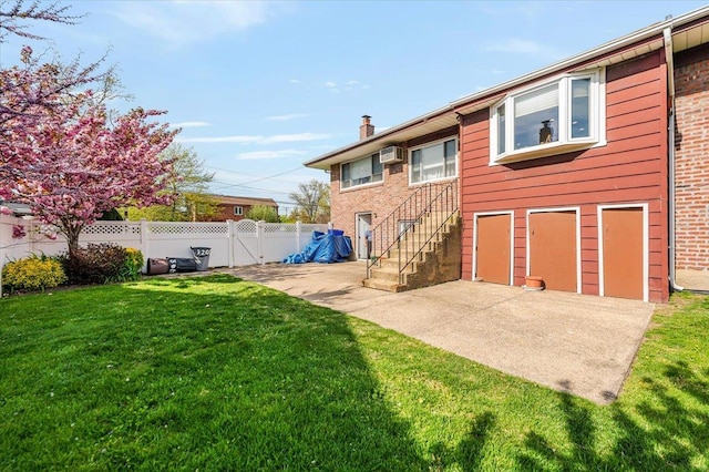 rear view of property with a chimney, a lawn, a patio area, stairway, and fence
